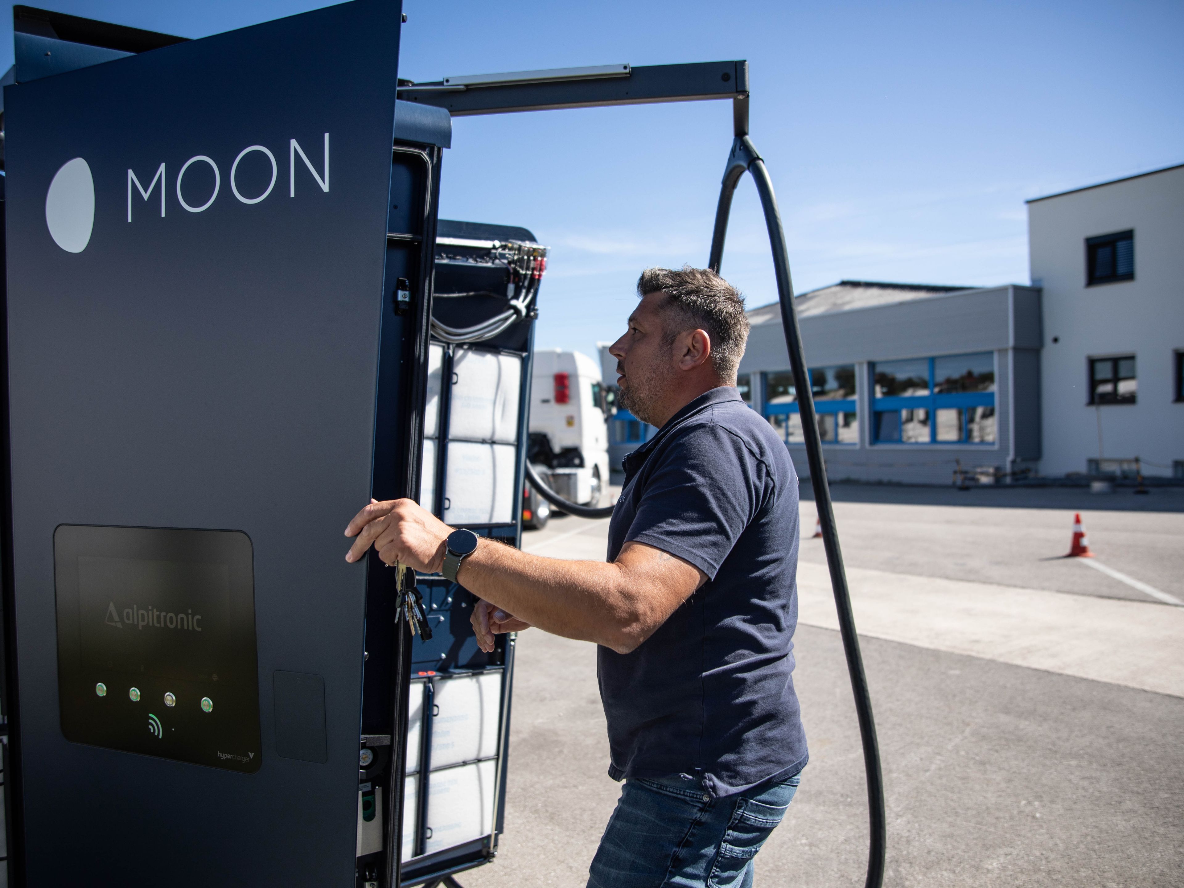 ein Mann steht vor einer offenen HYC 200-400 Schnellladestation