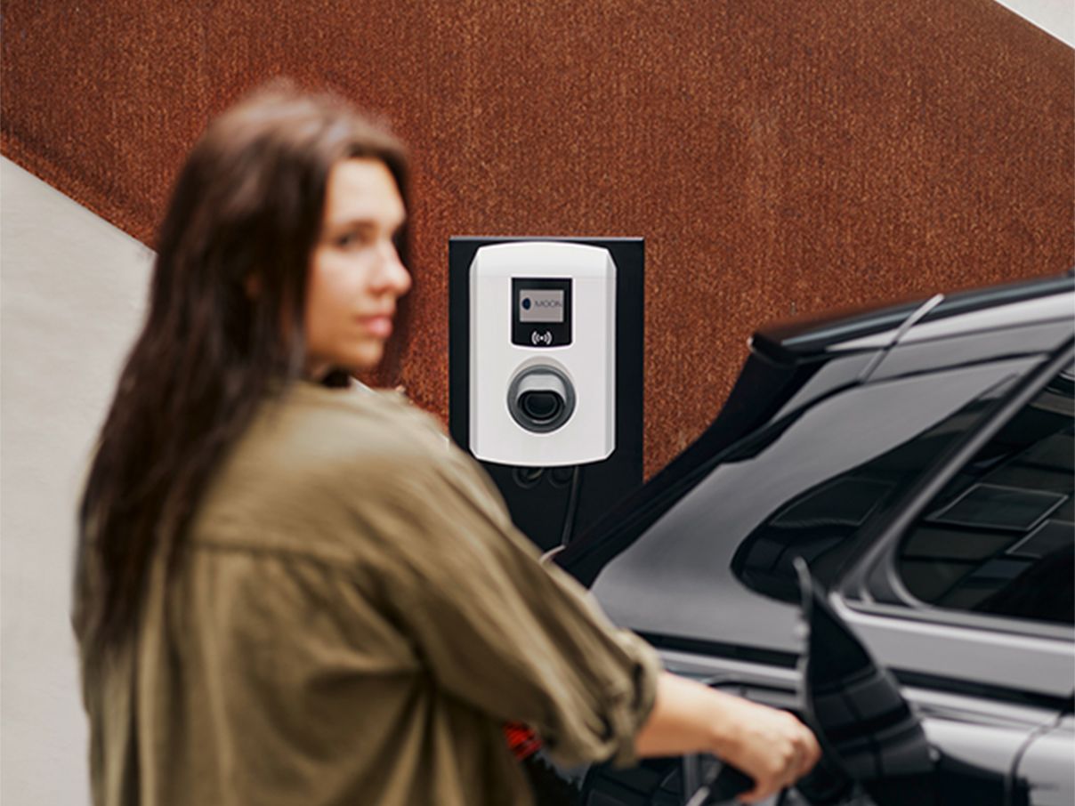 Frau lädt E-Auto mit einer Wallbox