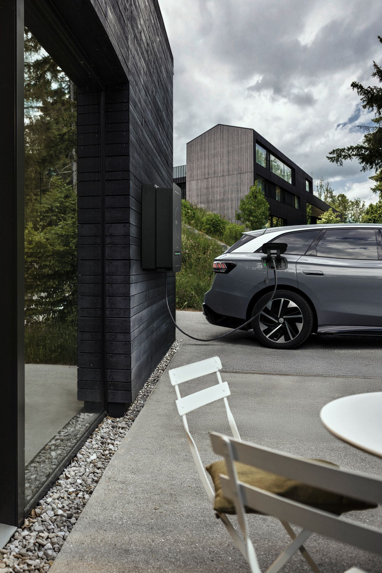 Mann in der Küche während Auto durch bidirektionale Wallbox Haus mit Strom versorgt