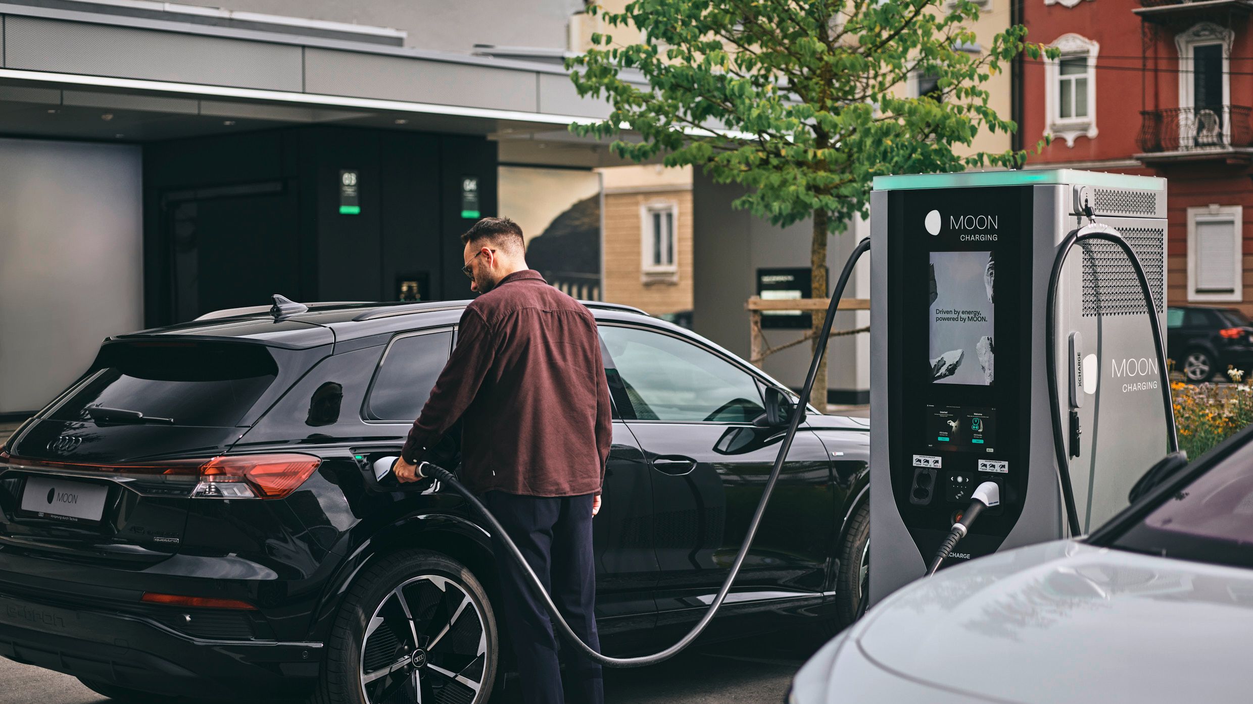 Person lädt E-Auto an Schnellladestation