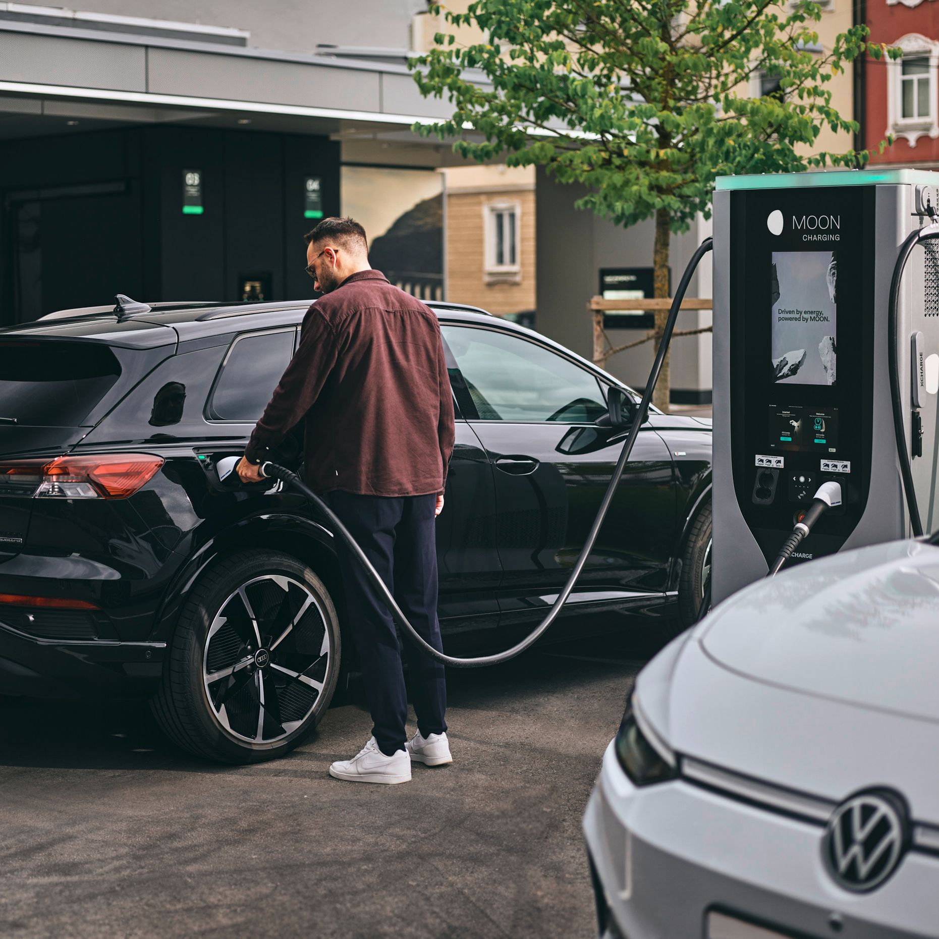 Person lädt E-Auto an Schnellladestation