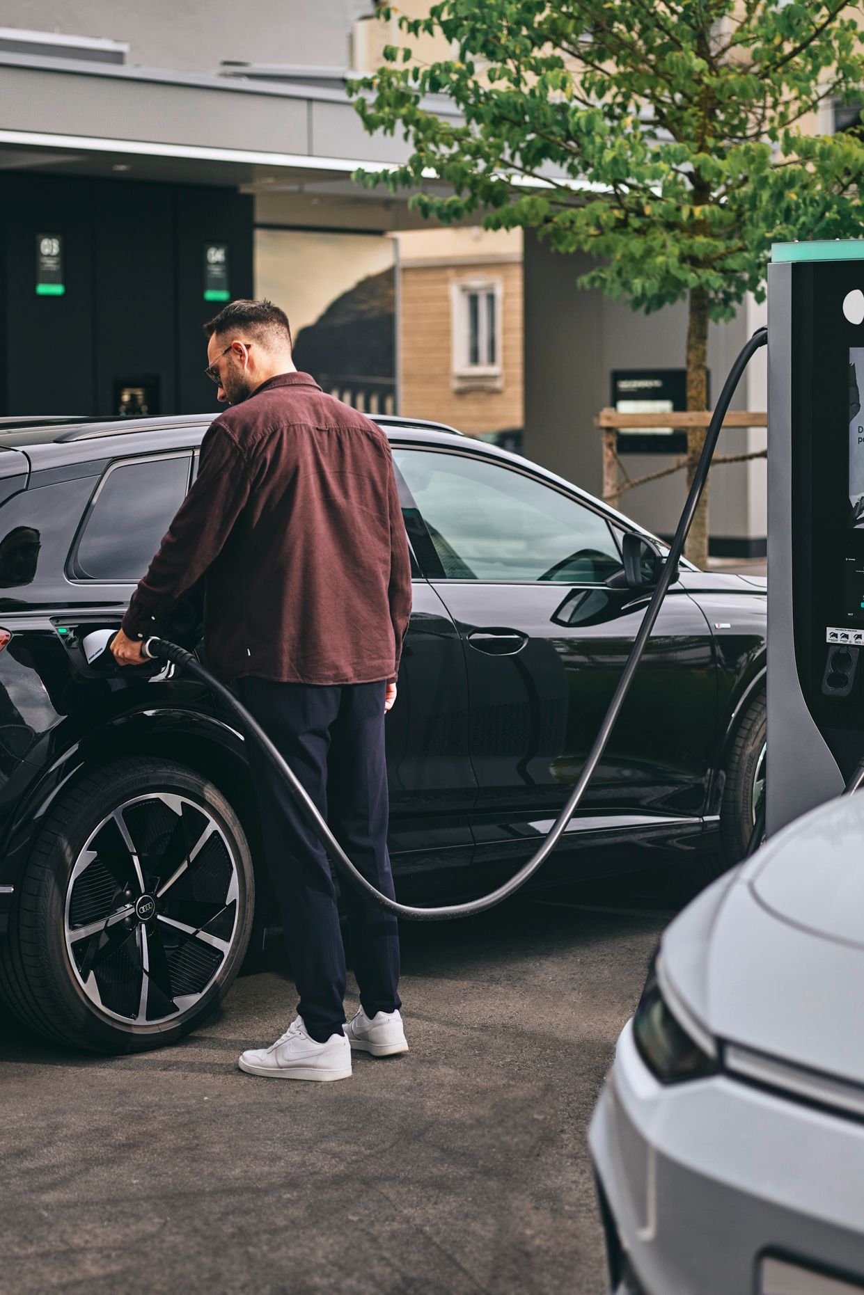 Person lädt E-Auto an Schnellladestation