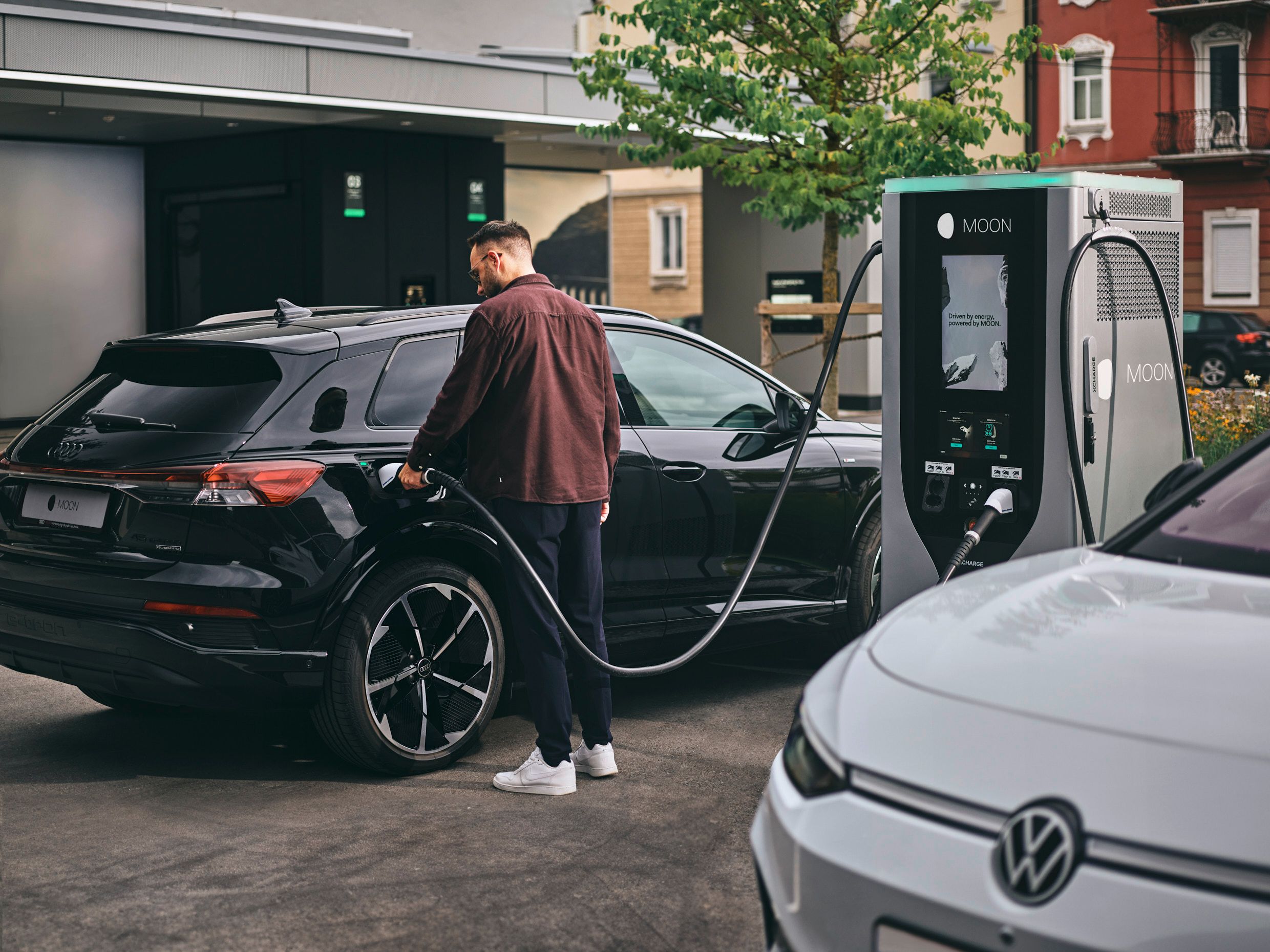 Person lädt E-Auto an Schnellladestation