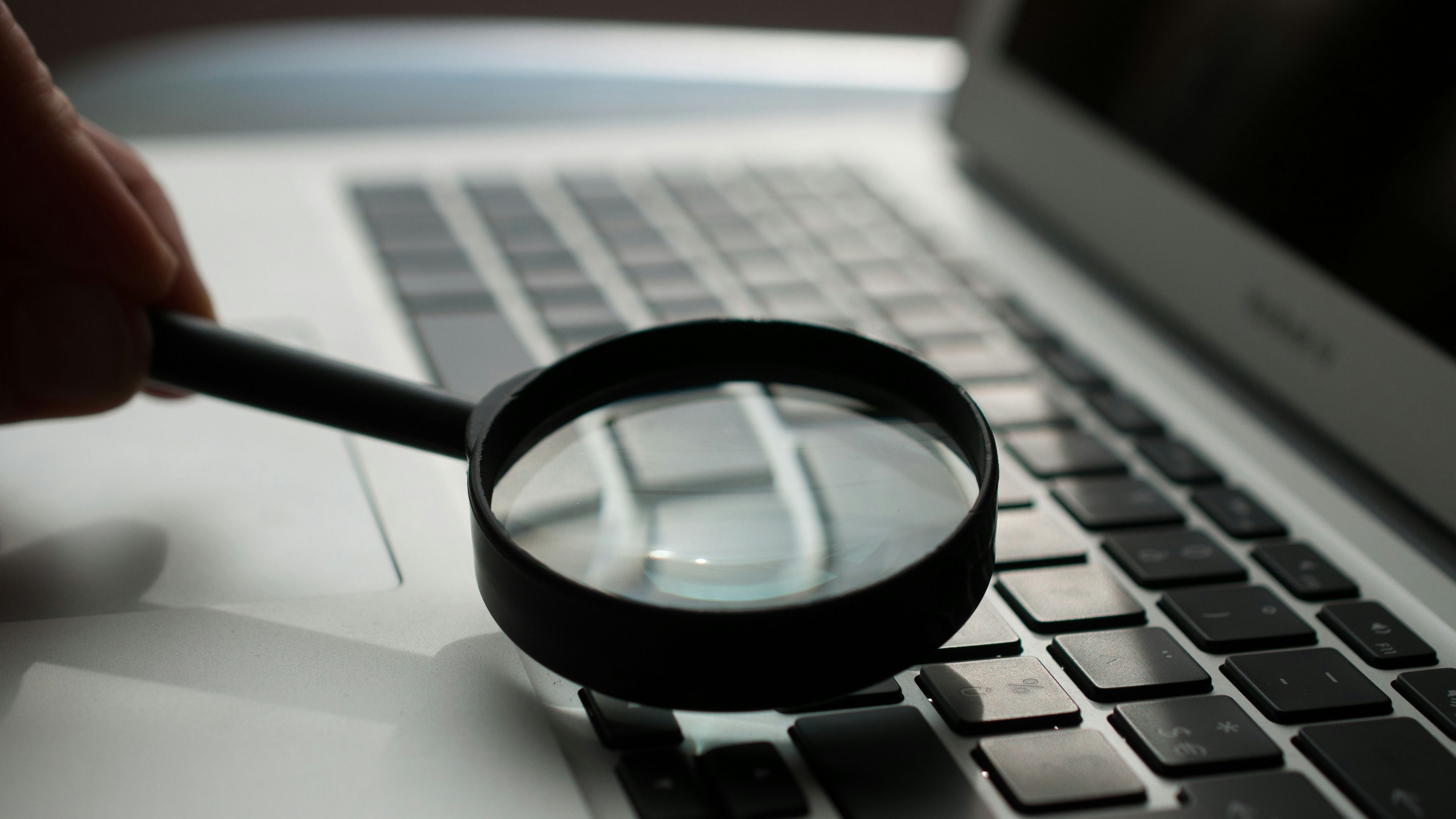 Lupe über grauem Laptop