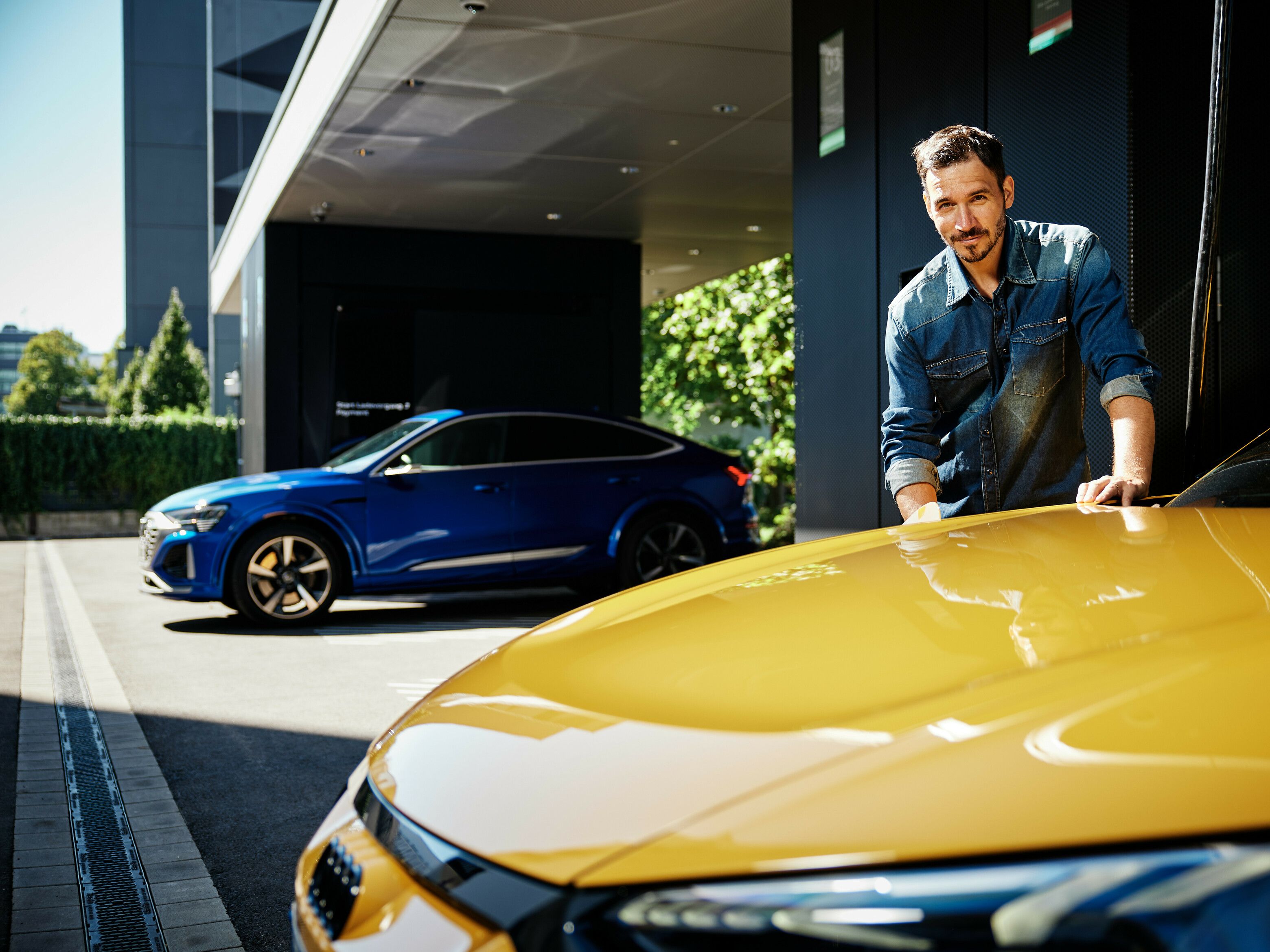 Mann lädt gelbes Auto an der Audi charging hub