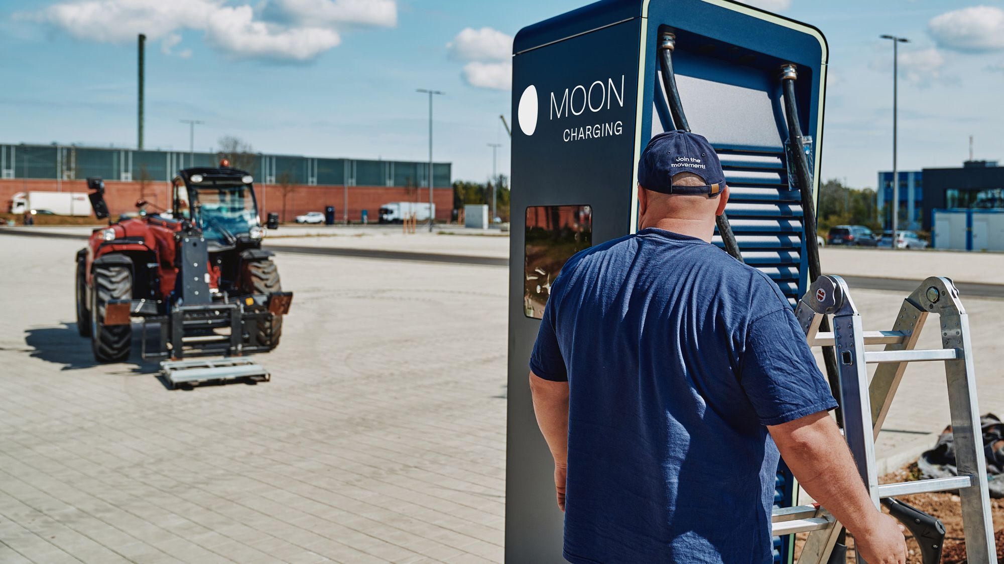 ein Mann steht mit einer Leiter vor dem POWER Charger