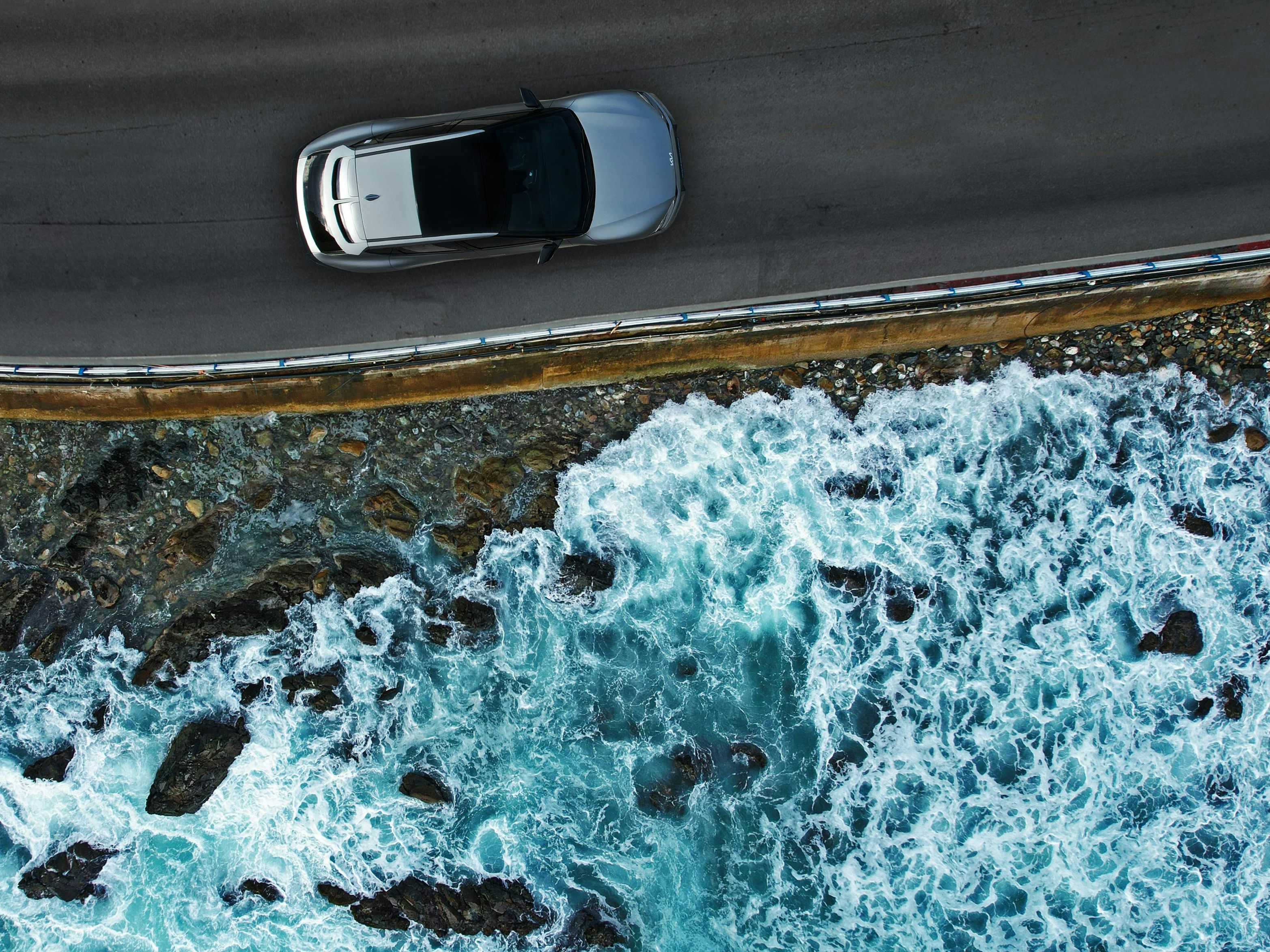 Luftaufnahme eines Autos, das am Meer entlangfährt 