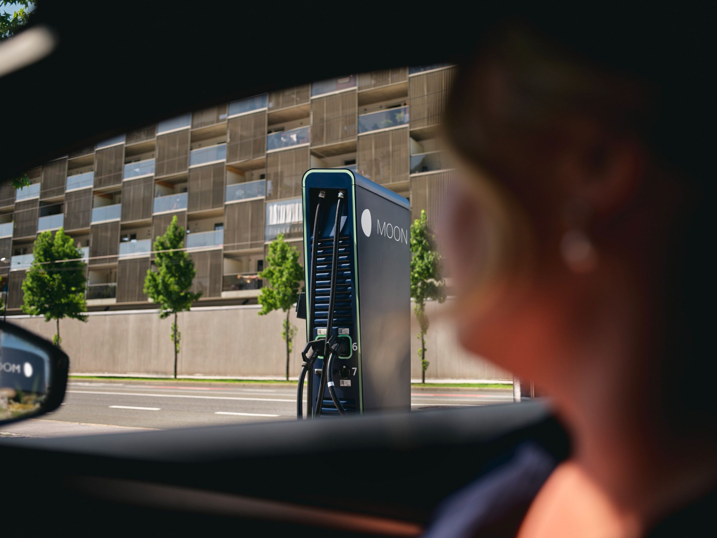 Schnellladestation hinter einem E-Auto