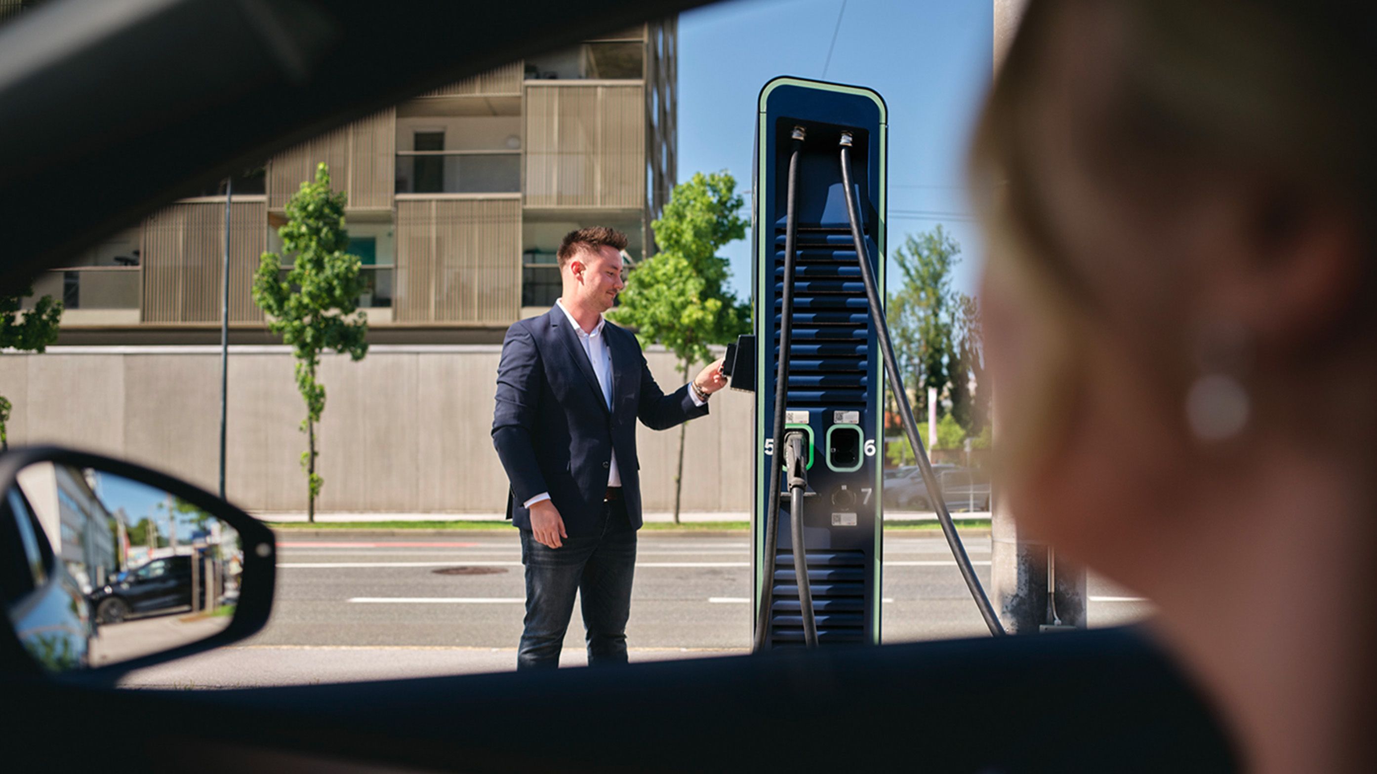 Person hält Karte an eine Ladestation